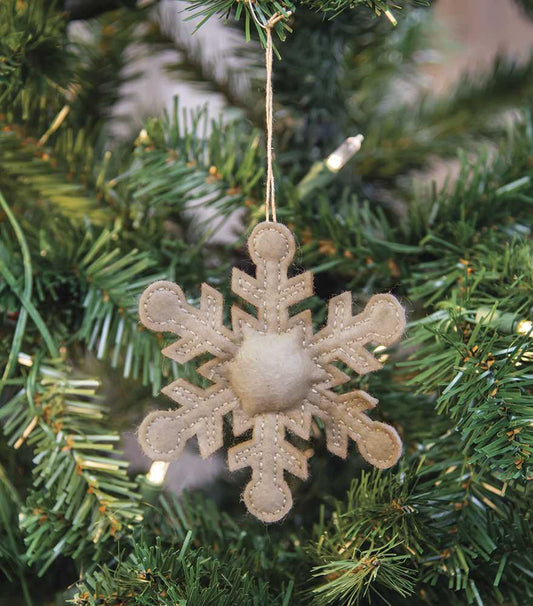 Antiqued snowflake ornament hanging from a Christmas tree