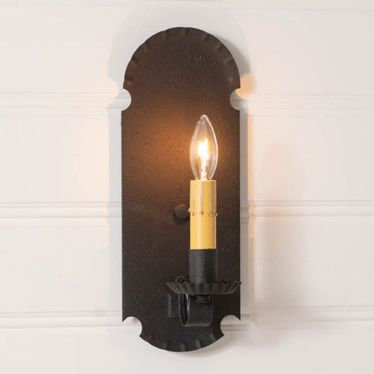 Decorative wall sconce with a lit candle-style bulb on a white background
