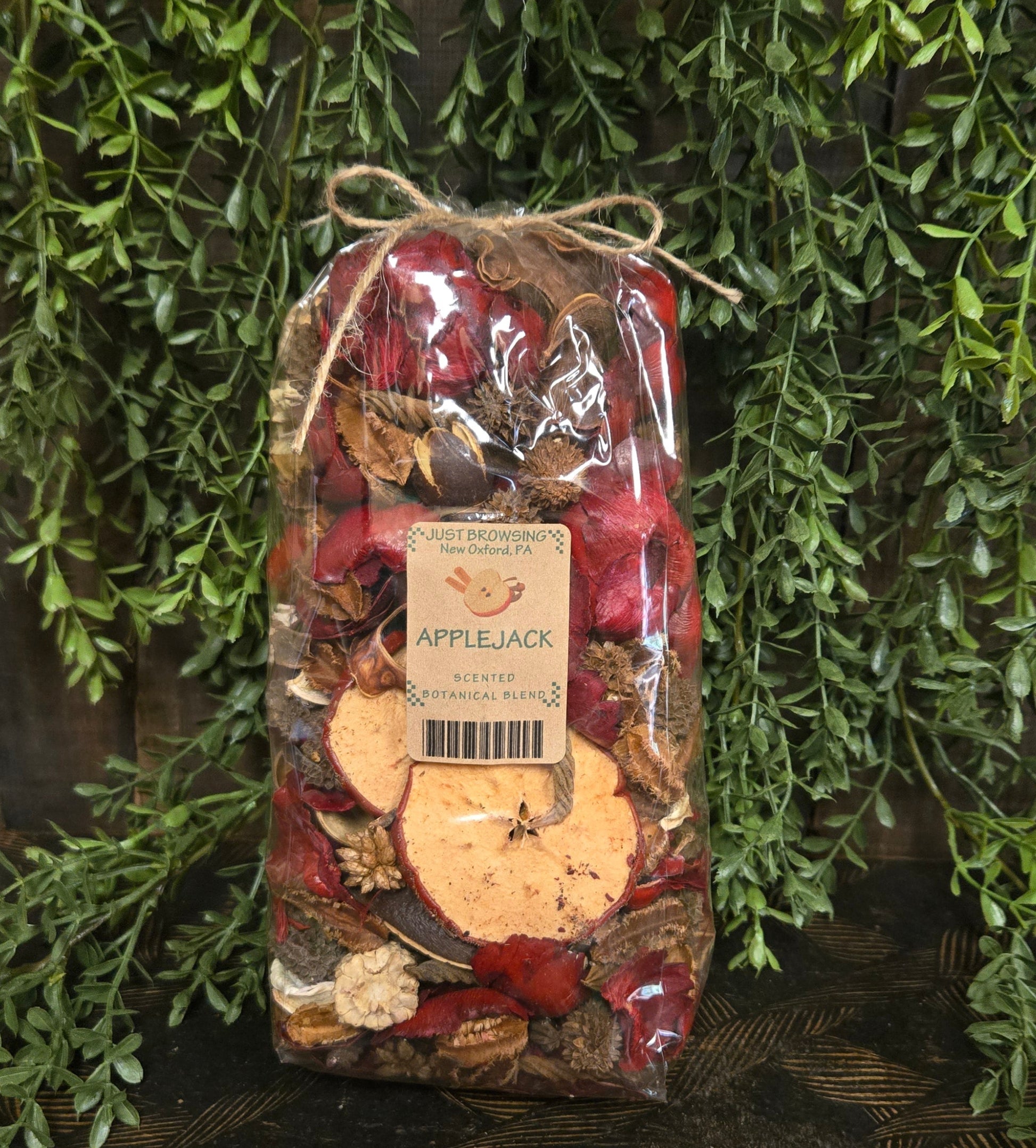 Packaged apple pie spice mix with a label on a decorative background of greenery
