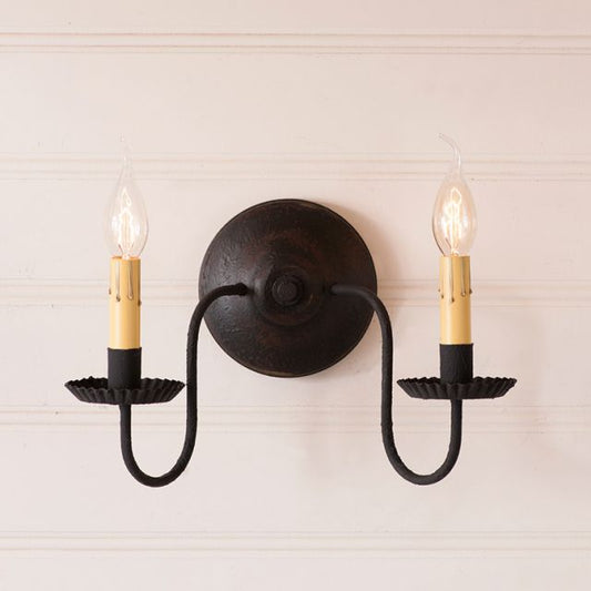 Black wall sconce with two candle-style light fixtures on a neutral background
