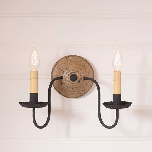 Double candle wall sconce with black and pearwood on a white wall.
