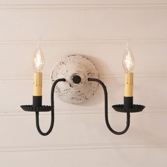 Wall sconce with two lit bulbs on a neutral background