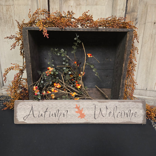 Decorative wall shelf with autumn-themed decor including a wooden sign and dried foliage.