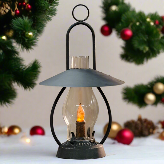 Vintage-style lantern with a lit candle on a wooden surface