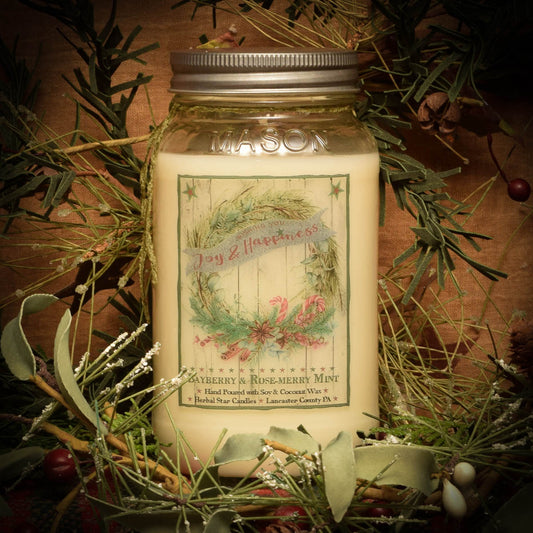 Mason jar candle labeled with artwork of a wreath and candy canes along with some text