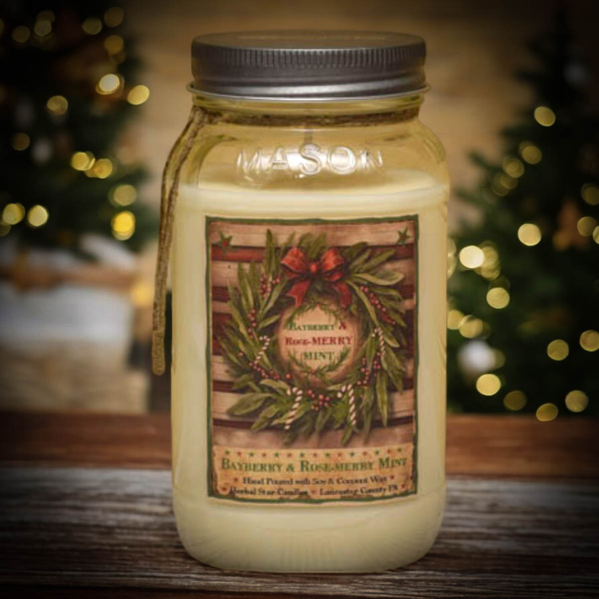 Jar candle with a Christmas-themed label on a wooden surface with blurred lights in the background