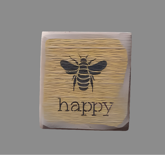 Weathered square wood sign with an illustration of a bee and the word "happy" underneath it.
