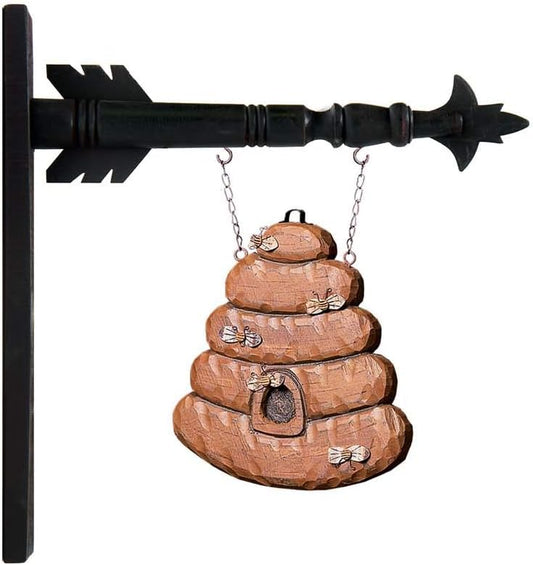 A brown wooden beehive-shaped arrow replacement with decorative elements, mounted on a black arrow-like structure.