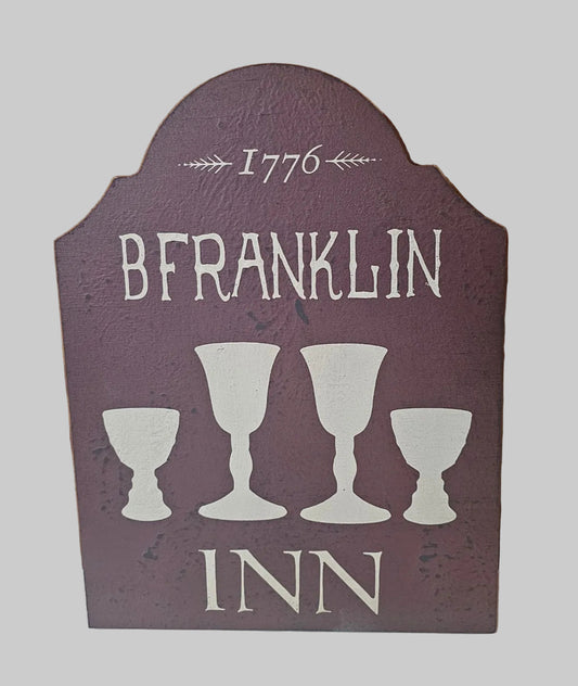 Decorative sign with 'BFranklin Inn' text and goblet designs on a gray background