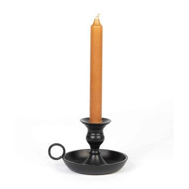 A black metal candle holder with a cylindrical base and a simple design, featuring a candle lit inside.