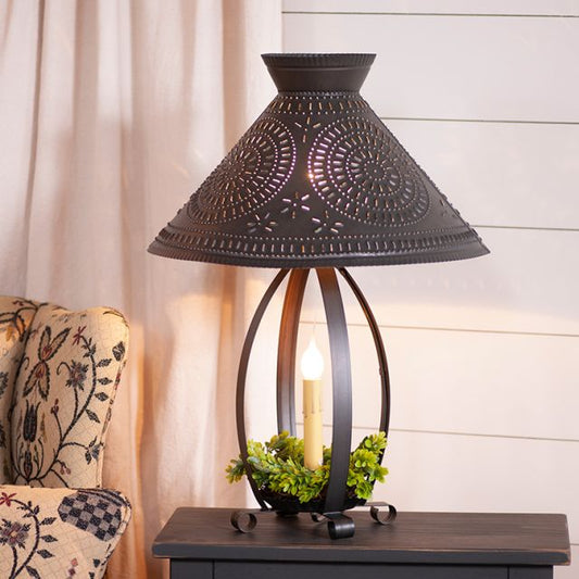 Decorative table lamp with intricate design on a wooden surface.