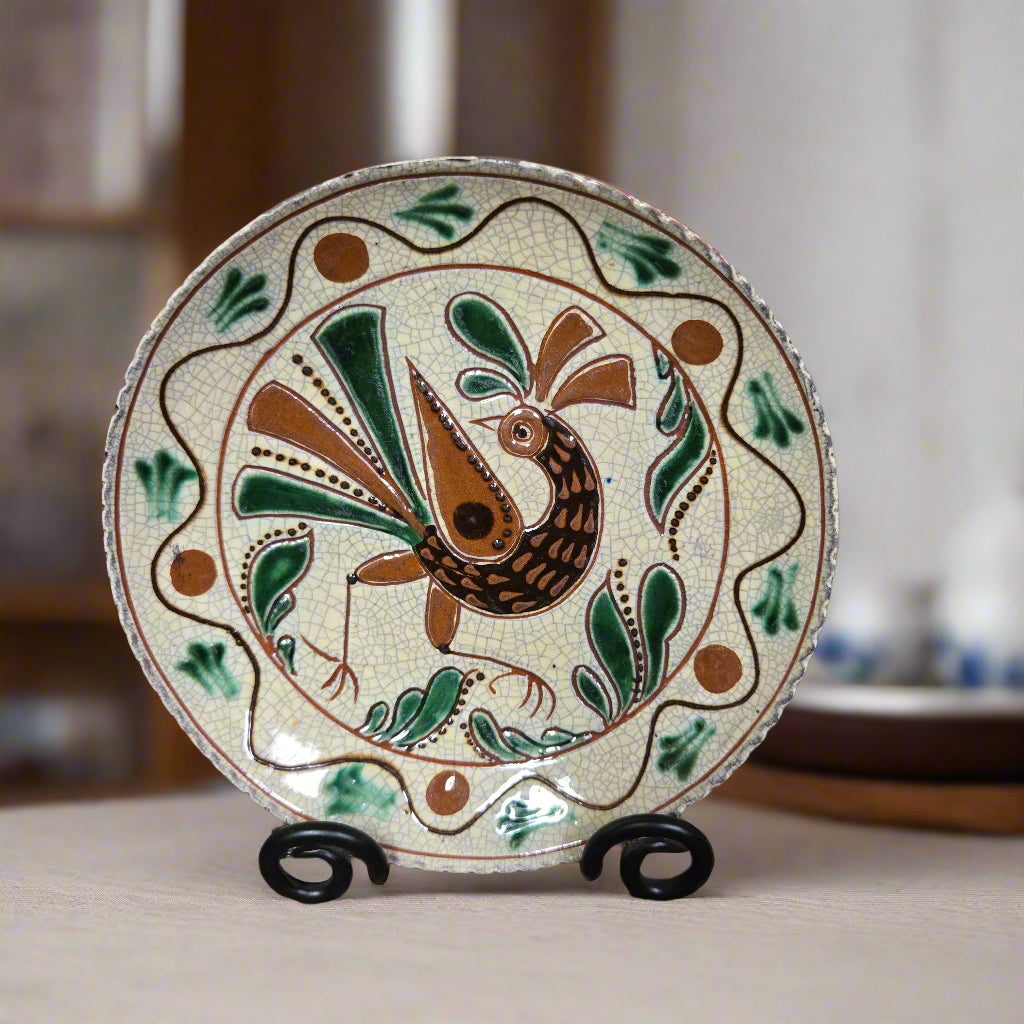 Redware plate with a bird and flower with a dotted border