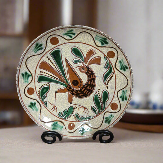 Redware plate with a bird and flower with a dotted border