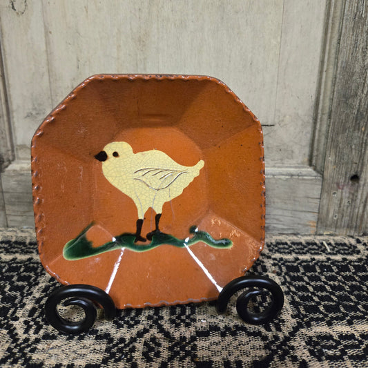 Octagonal redware plate with a bird motif with cream color glazing