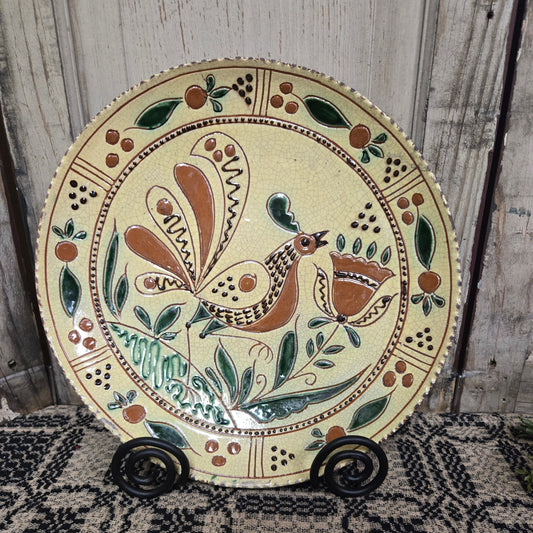 Decorative plate with a bird design on a wooden surface