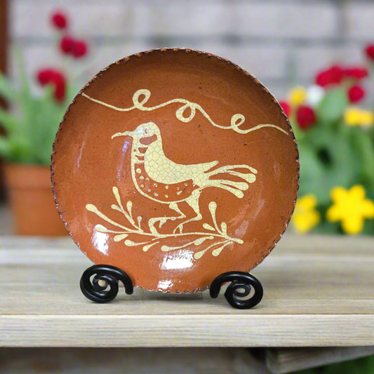 Ceramic plate with a bird design on a stand, floral background