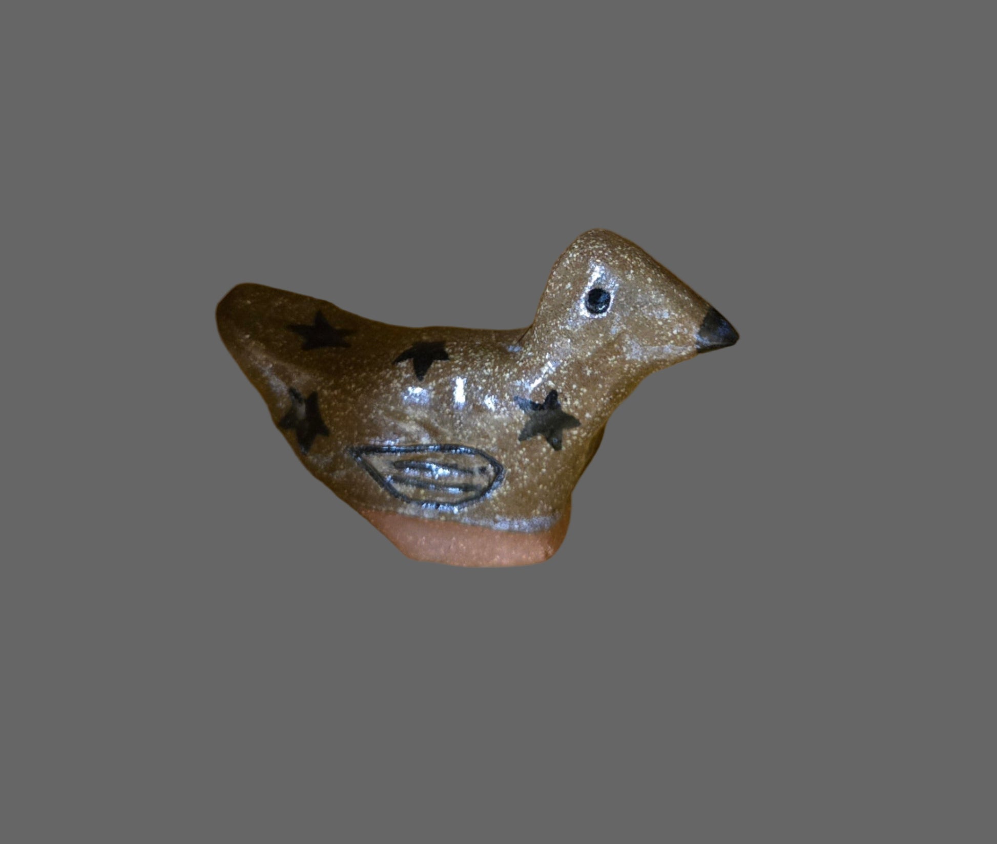 A miniature stoneware sculpture of a bird with a glazed finish in various colors.