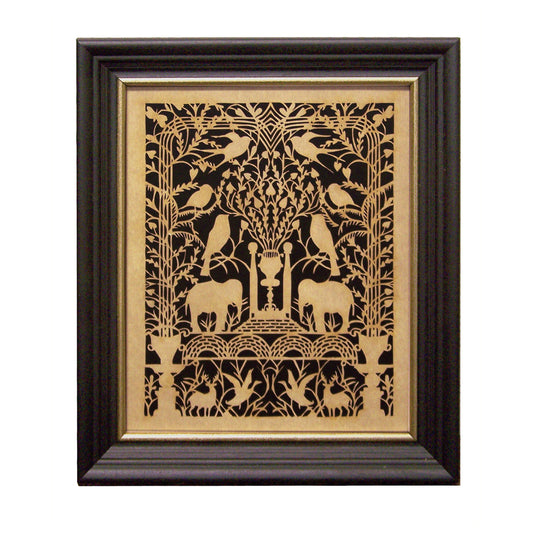 A framed scherenschnitte artwork featuring a detailed black and gold design with birds, elephants, and floral elements on a black background, housed in a black wood frame with gold edge.