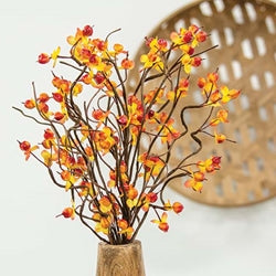 Artificial floral spray with brown-wrapped stems and orange bittersweet berries, displayed in a pitcher.