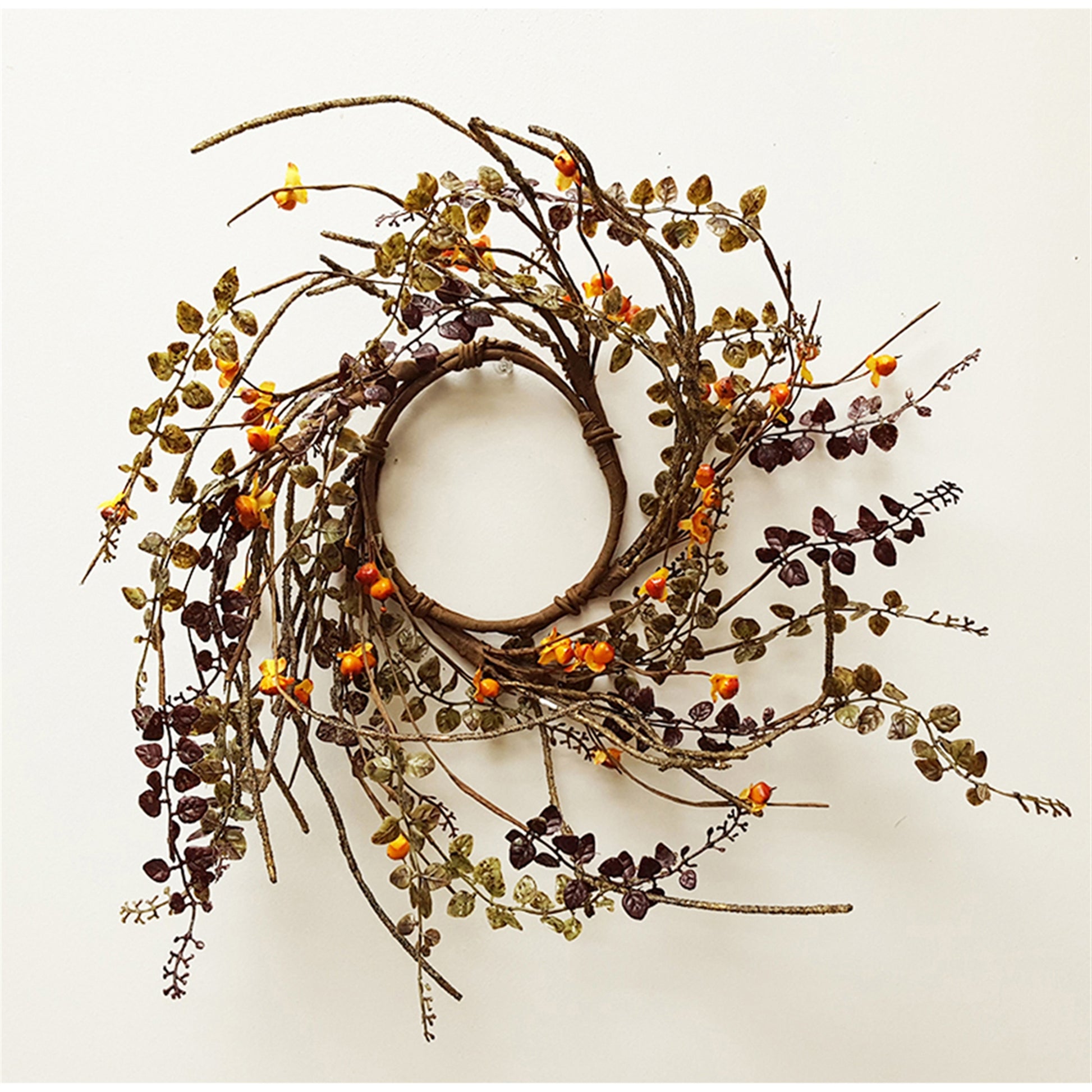 A brown candle ring with green leaves and orange berries.