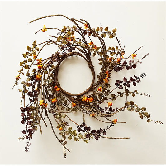 A brown candle ring with green leaves and orange berries.