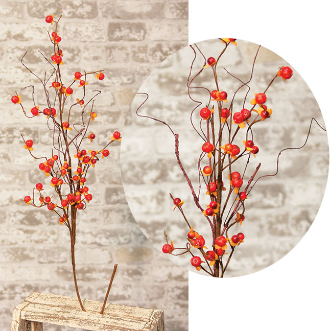 Decorative branches with red berries on a textured surface
