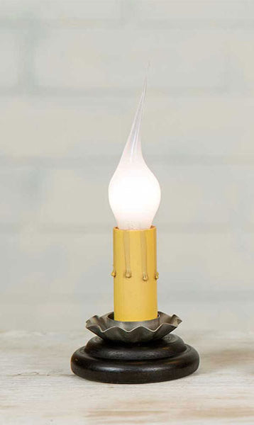 A black table lamp with a white light bulb, featuring a textured base and a simple design.
