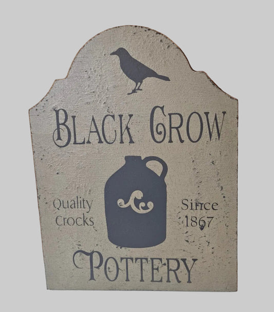 Decorative sign for Black Crow Pottery with a jug and crow design on a light gray background
