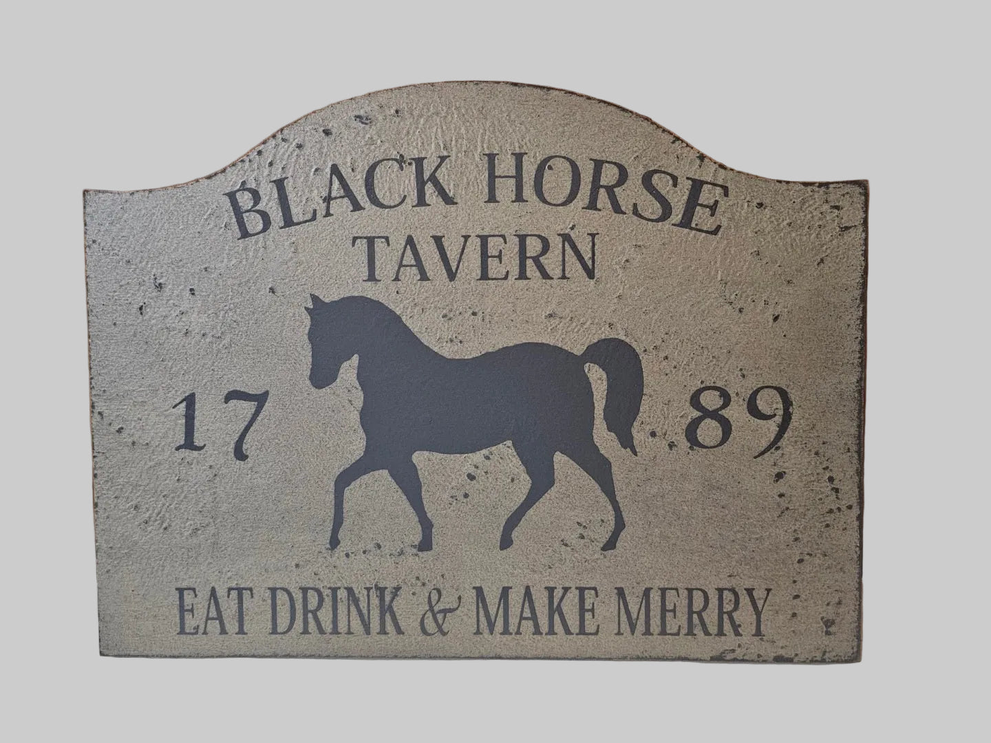 Decorative sign for Black Horse Tavern with horse silhouette and text on a gray background
