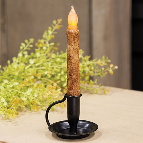 Decorative candle with a textured holder on a neutral background