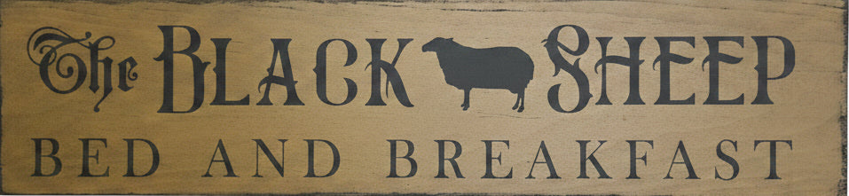 Wooden sign with 'The Black Sheep Bed and Breakfast' on a wooden background