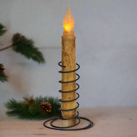Decorative candle with spiral design and glowing flame on a white background