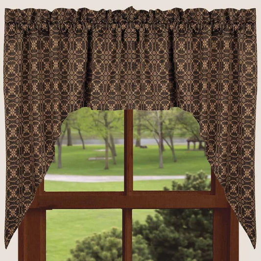 Decorative curtain with a patterned design in front of a window with a view of trees and grass.