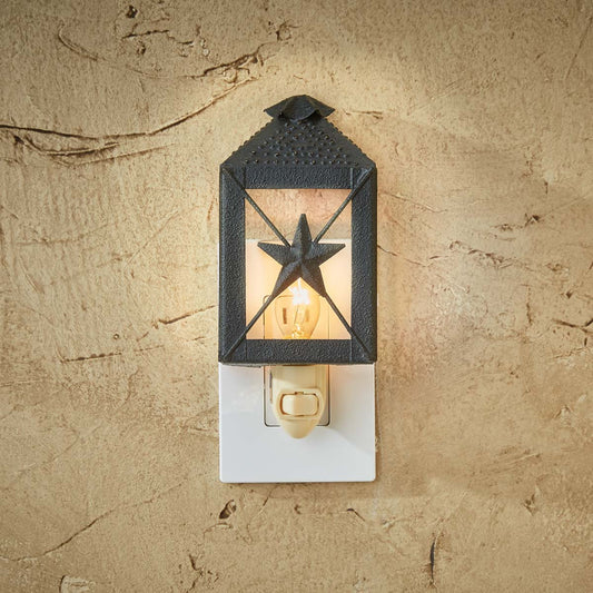 A black lantern-shaped night light with a star cut-out, mounted on a wall.