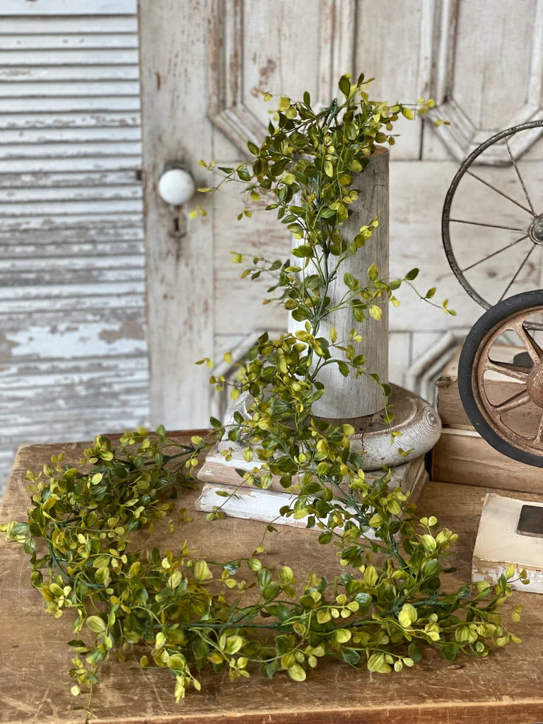Artificial greenery on a wooden surface with rustic background