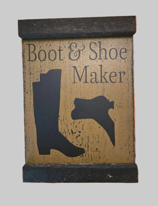Decorative sign with 'Boot & Shoe Maker' text and silhouette of a boot and shoe on a wooden background.
