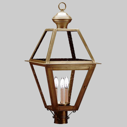 Decorative outdoor lamp with brass finish on a gray background