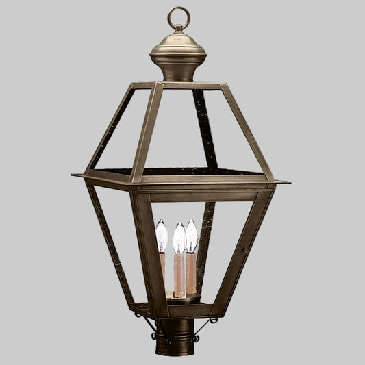 Decorative outdoor lantern with a metallic finish on a gray background