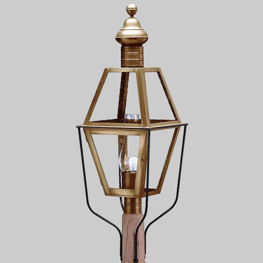 Decorative outdoor lamp with brass finish on a gray background
