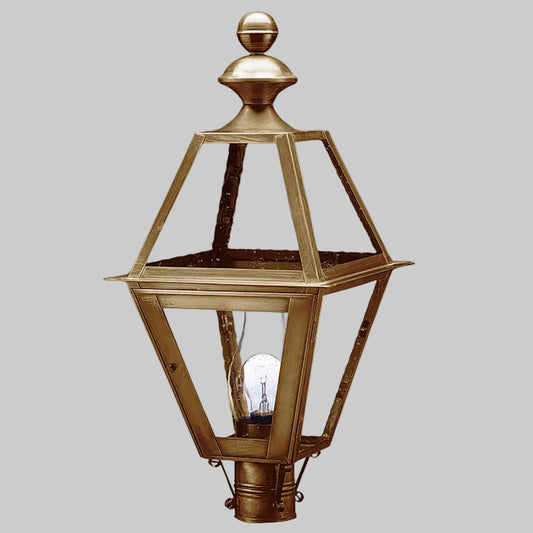Decorative brass outdoor lamp with clear glass on a gray background