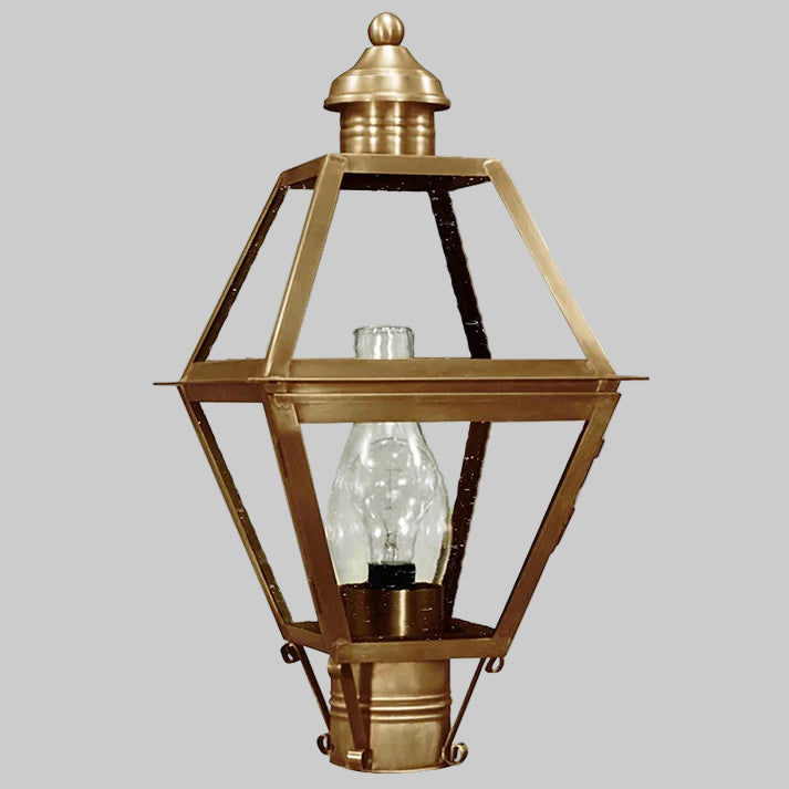 Brass outdoor lamp with clear glass shade on a gray background