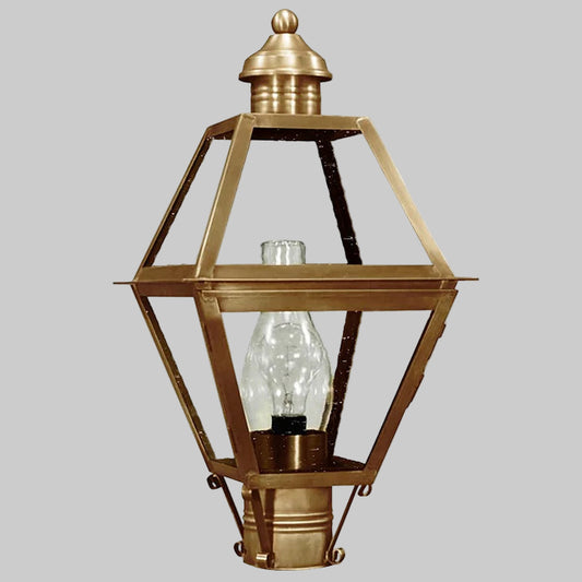 Brass outdoor lamp with clear glass shade on a gray background