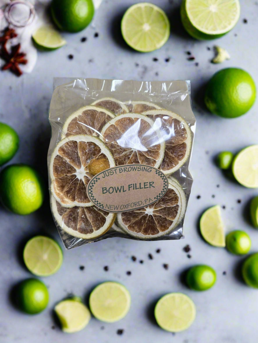 Packaged bowl filler with dried citrus slices on a background of limes