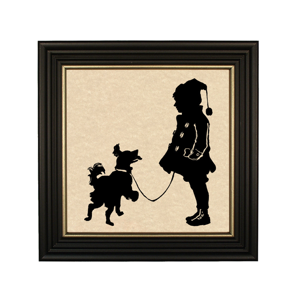 A paper cut silhouette of a boy and a dog, framed in a black solid ash wood frame with gold trim.