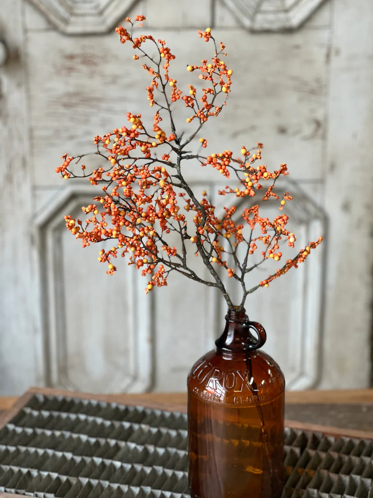 Pumpkin color floral pick in brown vase