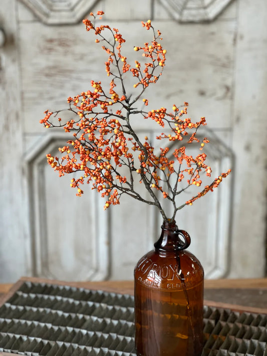 Pumpkin color floral pick in brown vase