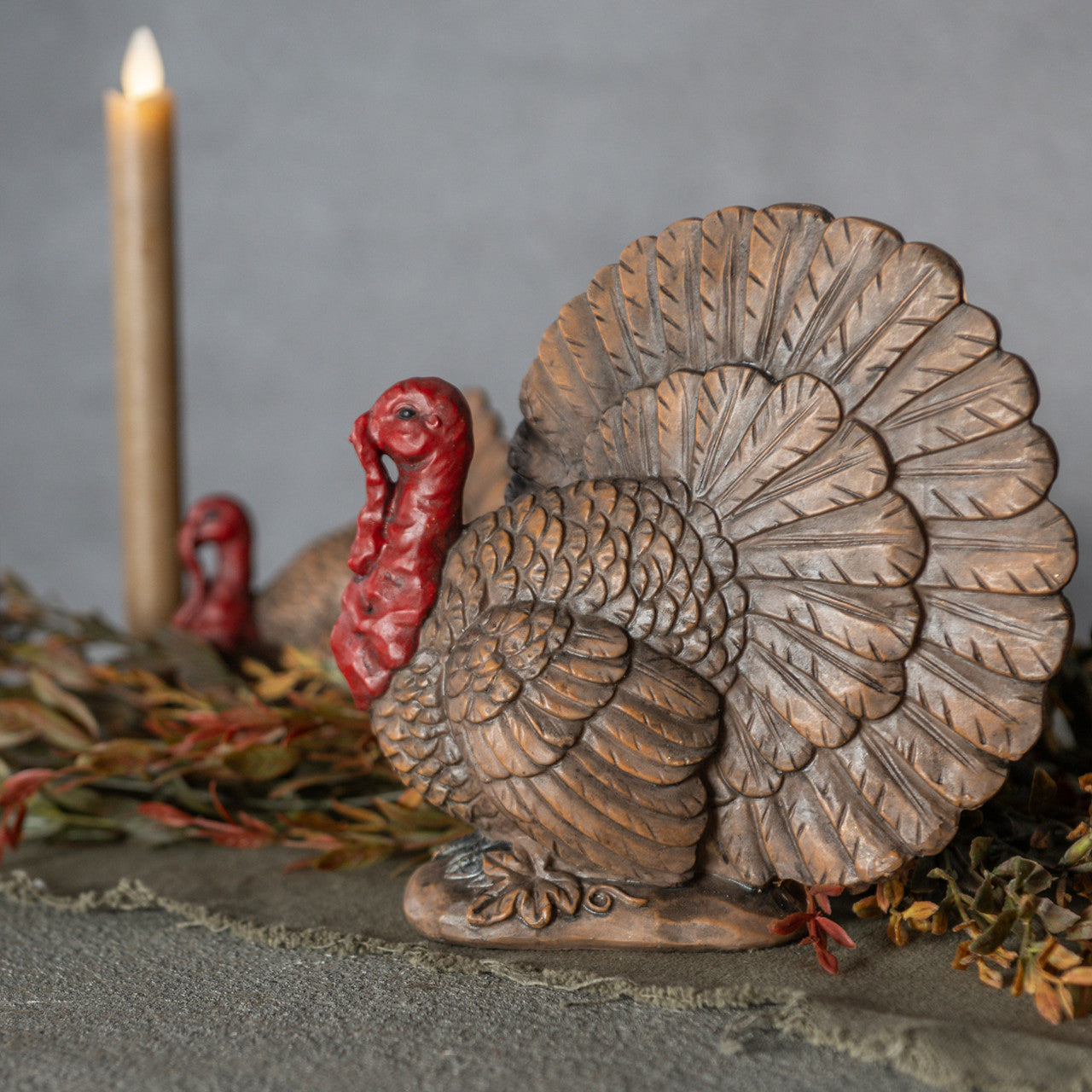 Resin turkey figurine with a candle on a neutral background