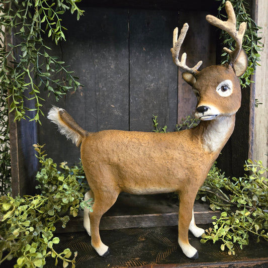Buck on a wooden background with greenery