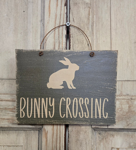 Wooden sign with a rabbit silhouette and 'Bunny Crossing' text on a wooden background