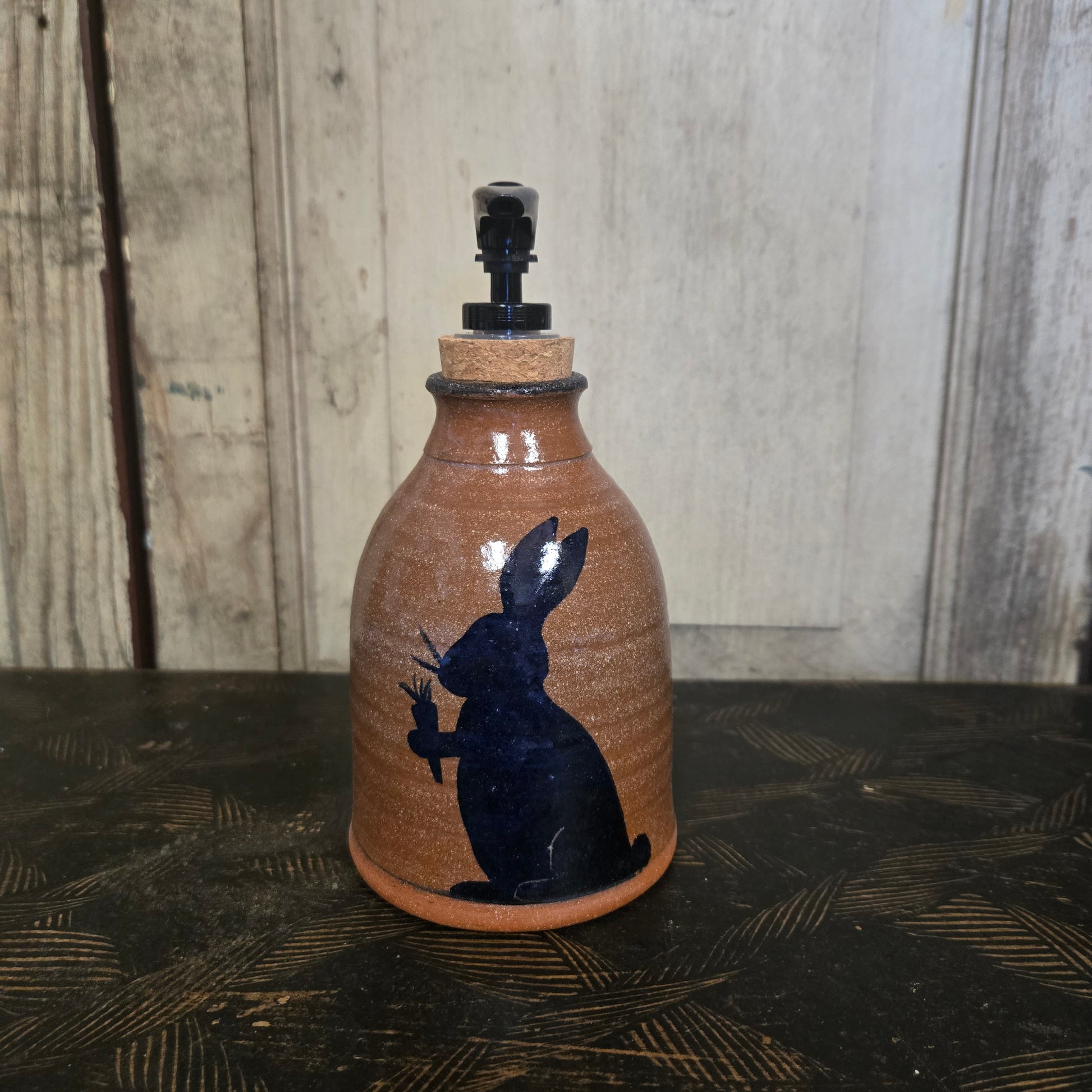 Decorative bottle with a rabbit design on a wooden surface